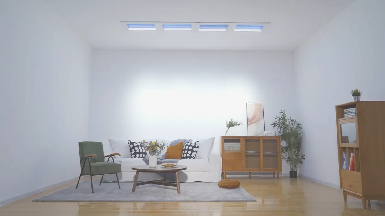 The same living room with the four skylights on, showing blue sky and filling the wall with daylight-coloured light