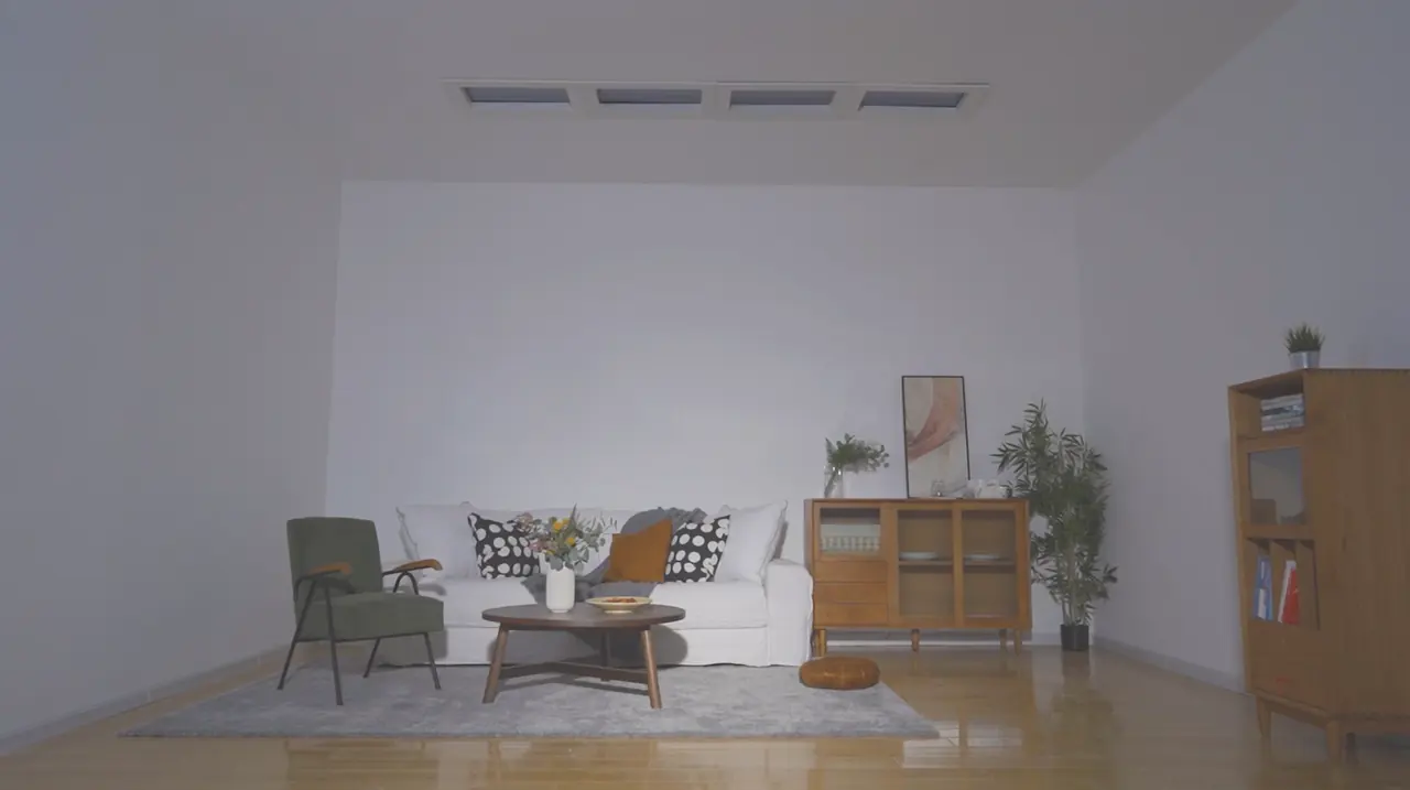 A living room with no windows, lit only by ordinary ceiling light, with the skylights switched off